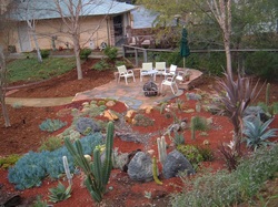 Rock patio amid water-wise xeriscape.